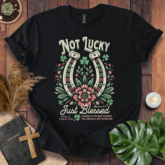“Not Lucky, Just Blessed” Romans 4:8 Christian t-shirt with twin horseshoes, clovers, and florals; western faith tee.