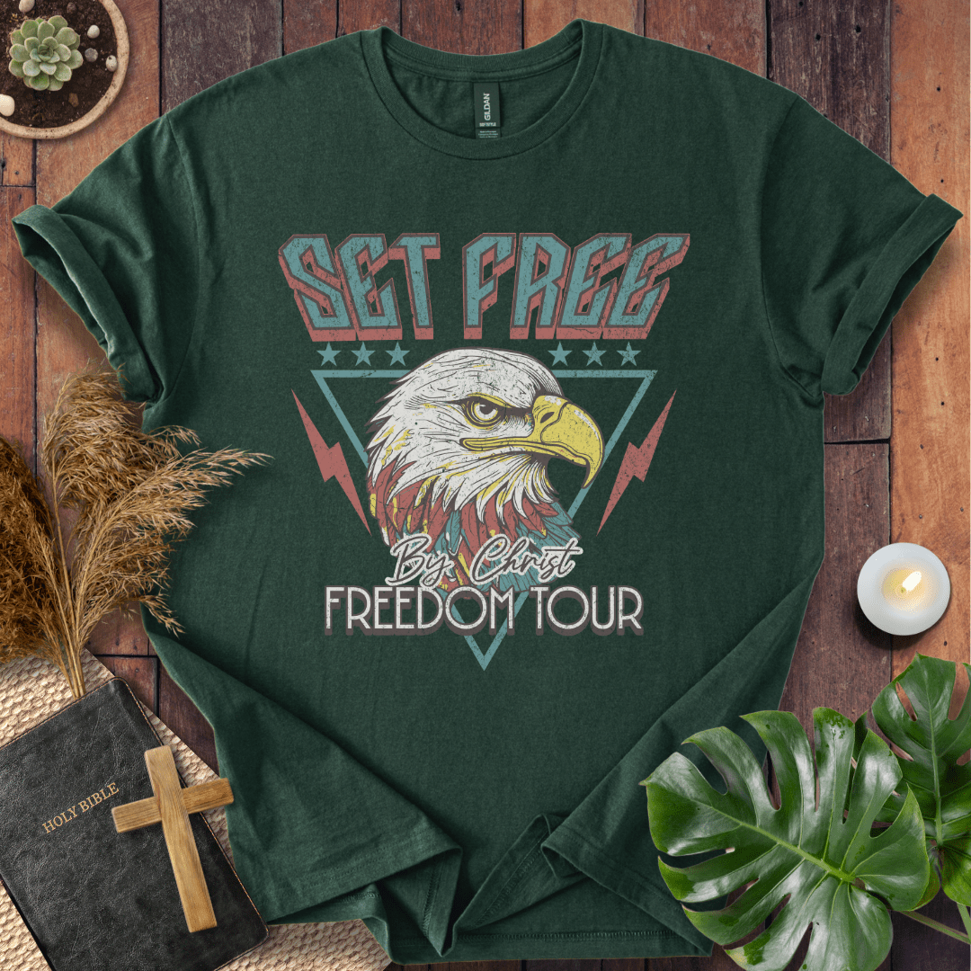 “Christian t-shirt with vintage eagle and ‘Set Free by Christ Freedom Tour’ design, styled as a flat lay with Bible and rustic Western elements.”