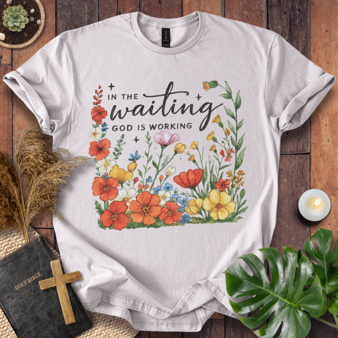 “In the Waiting God Is Working” Christian t-shirt with hand-lettered script and floral frame; encouragement faith tee.