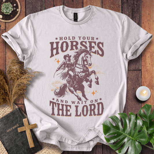 Cowgirl riding a rearing horse on a t-shirt with text saying Hold Your Horses and Wait on the Lord.