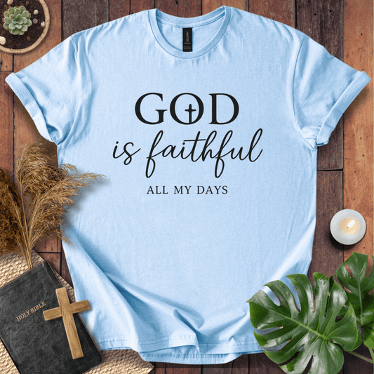 Christian t-shirt reading "God is Faithful All My Days" on a rustic wood background with a Bible and cross.