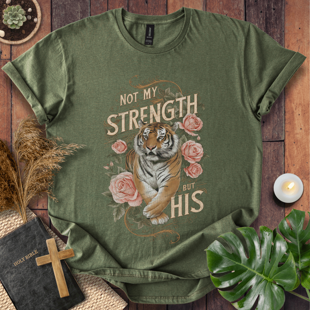 Not My Strength But His Christian t-shirt in black—tiger with roses and vintage script faith design.