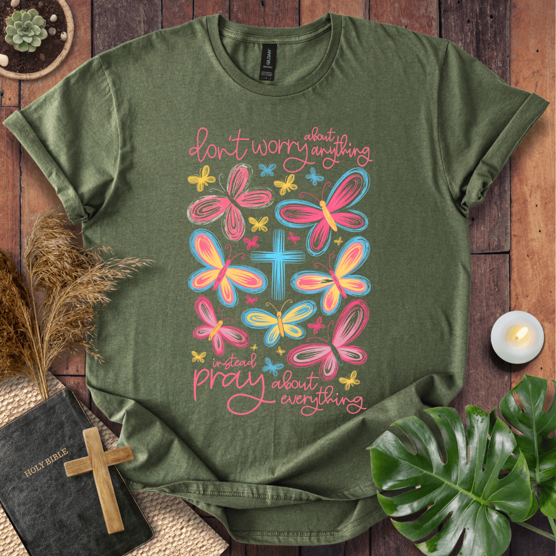 butterfly faith shirt with a Bible and cross on a rustic wooden background.