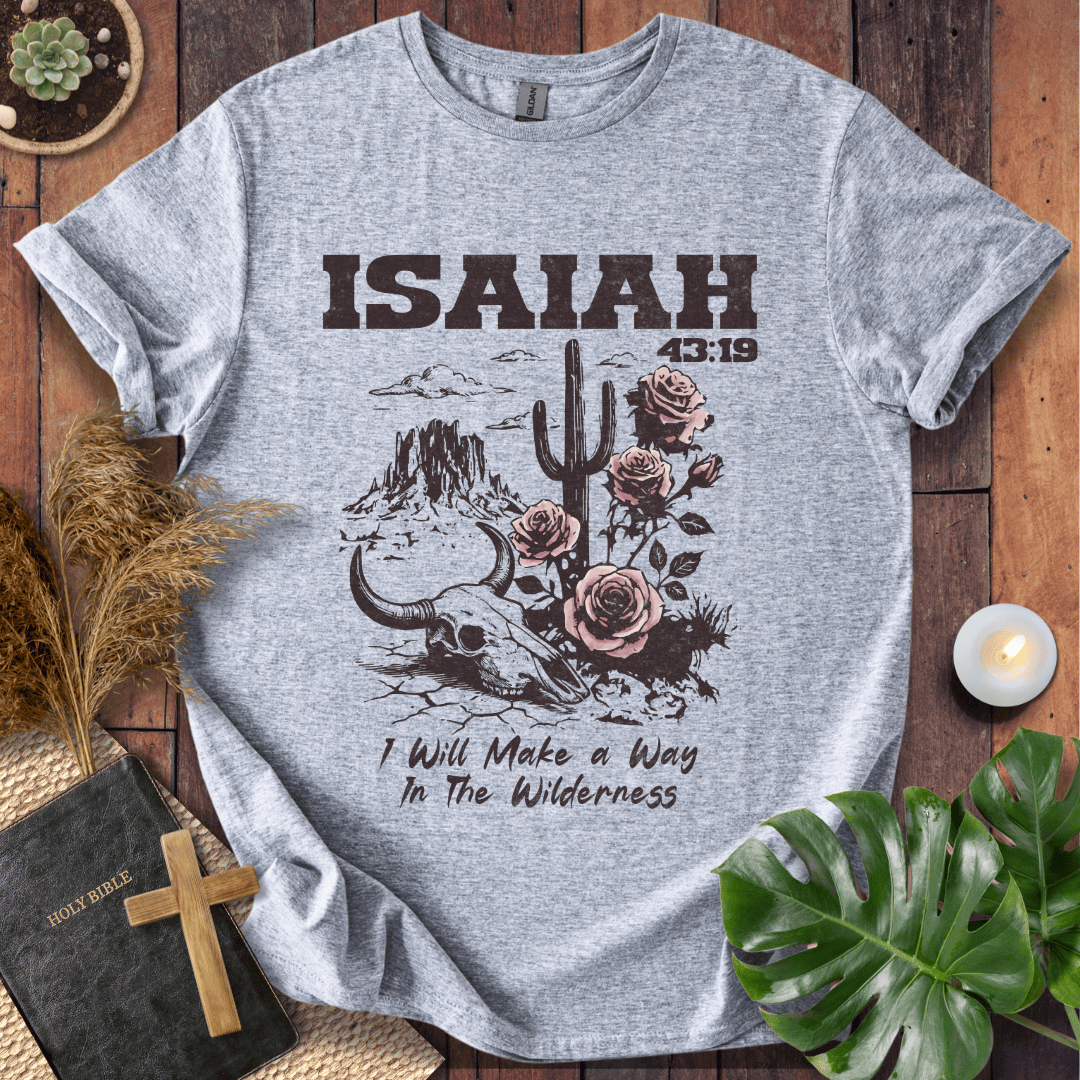 Gray t-shirt with 'ISAIAH 13:19' design on a wooden surface with plants and a Bible.