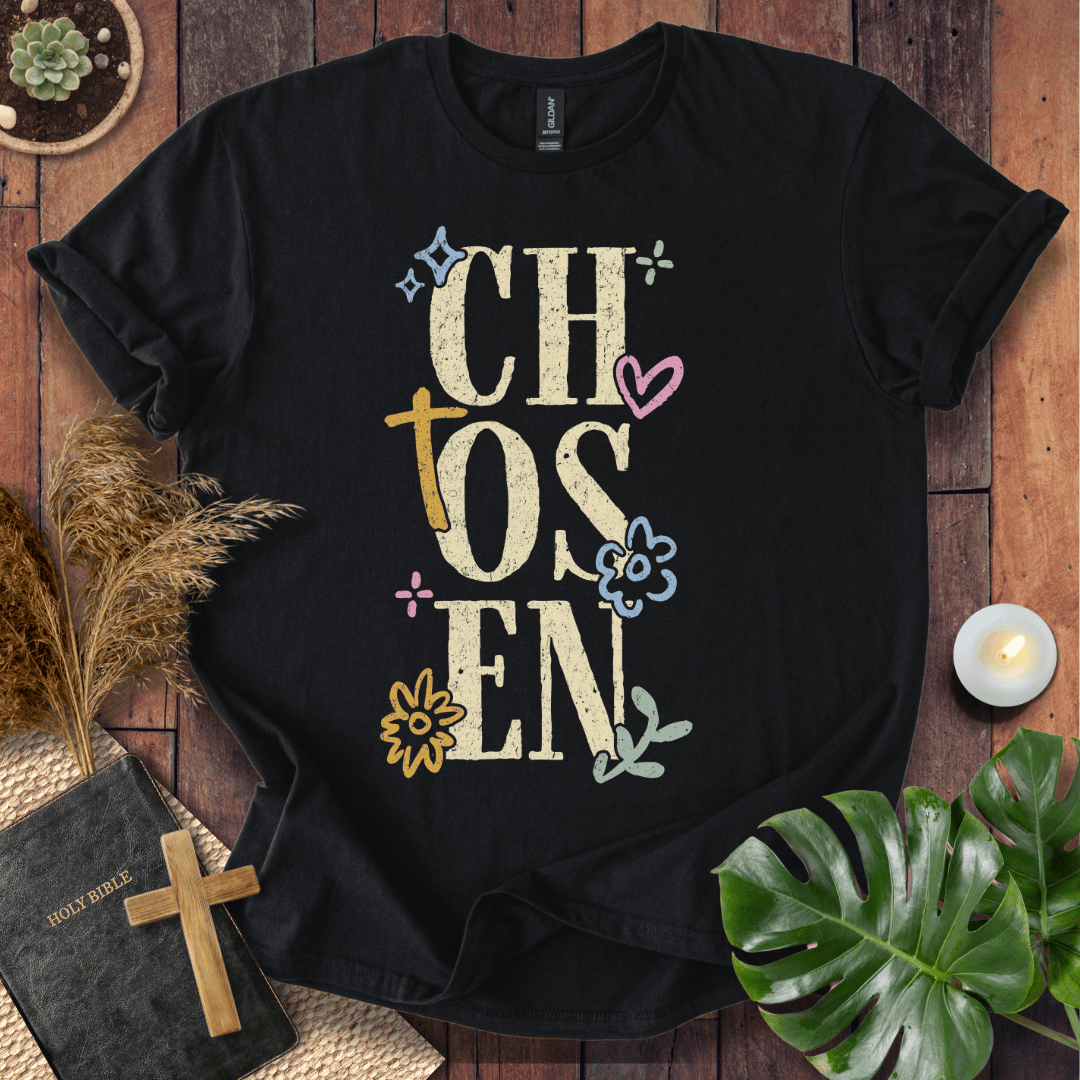 Distressed "CHOSEN" graphic on a t-shirt with a rustic gold cross and colorful boho wildflowers.