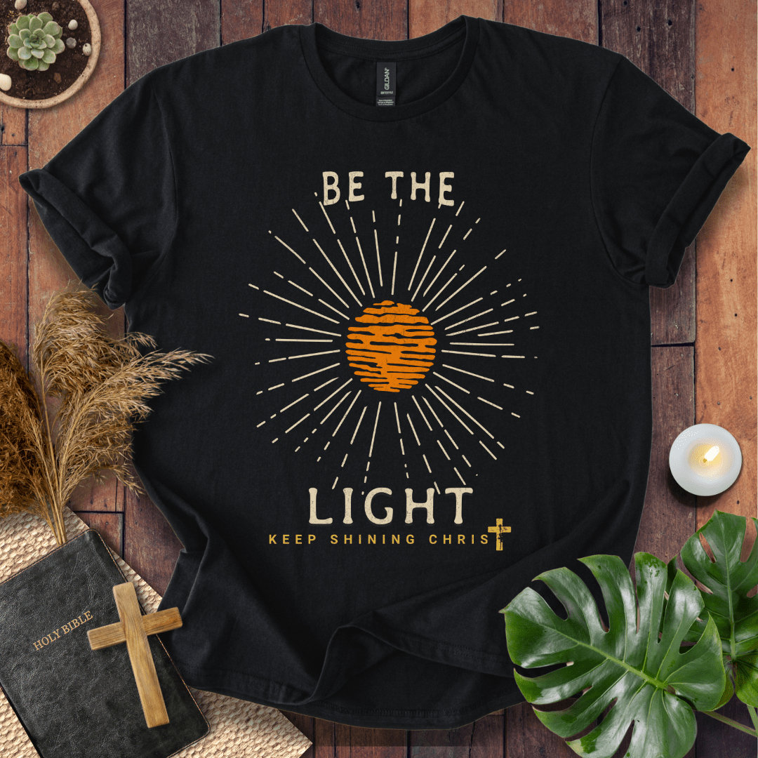 Be the Light Christian t-shirt—radiant sunburst with “Keep Shining Christ,” inspired by Matthew 5:14–16.