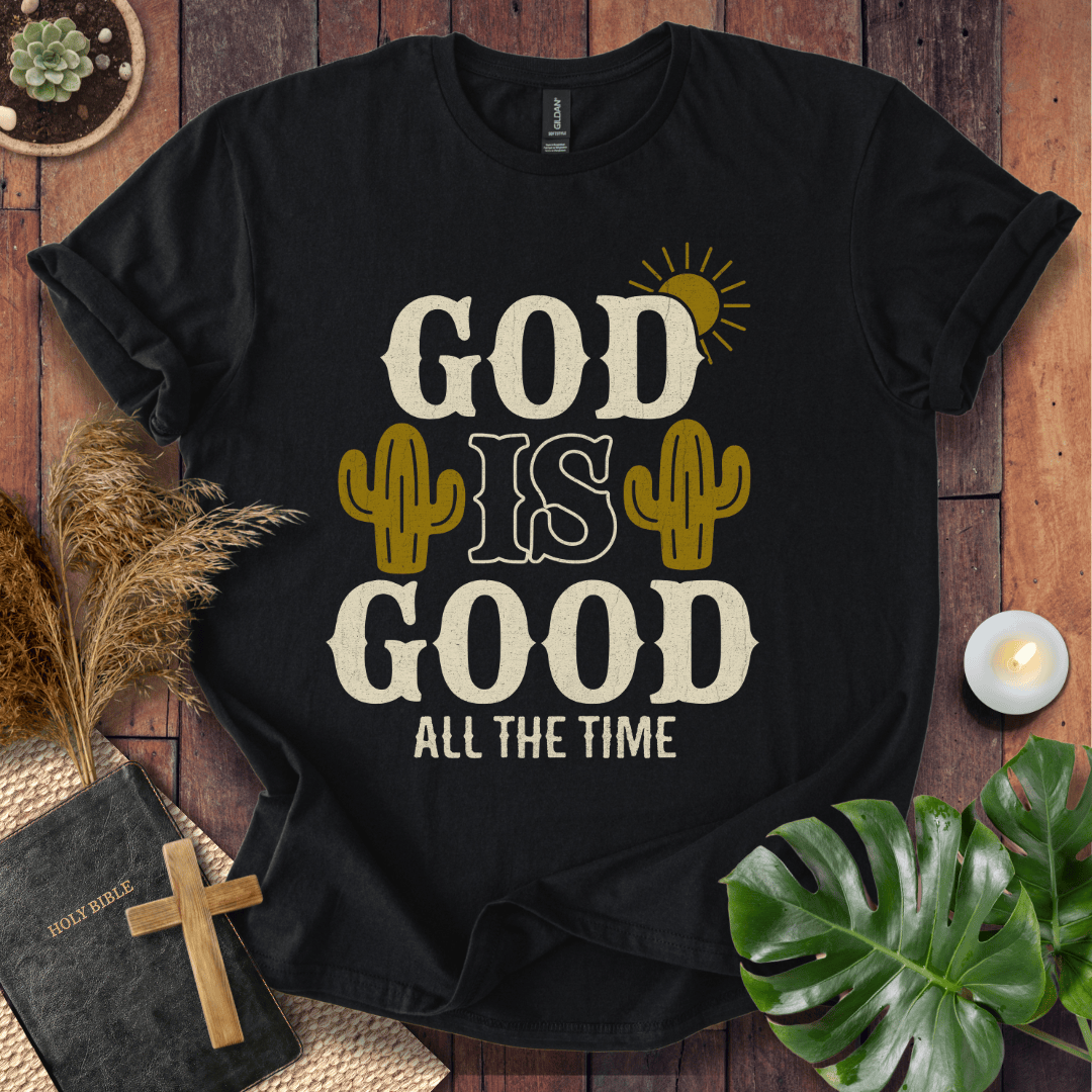 God Is Good All The Time t-shirt with cacti and sun graphics, styled with a Bible and wooden cross.