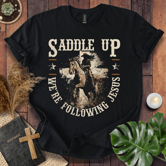 t-shirt featuring a horse and rider silhouette on a cross with text Saddle Up We're Following Jesus in a vintage style.