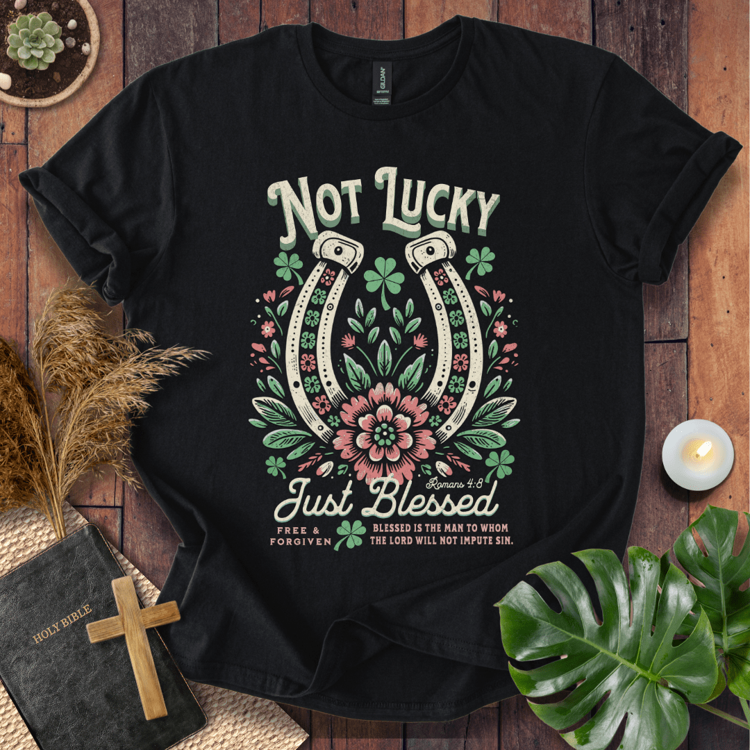 “Not Lucky, Just Blessed” Romans 4:8 Christian t-shirt with twin horseshoes, clovers, and florals; western faith tee.
