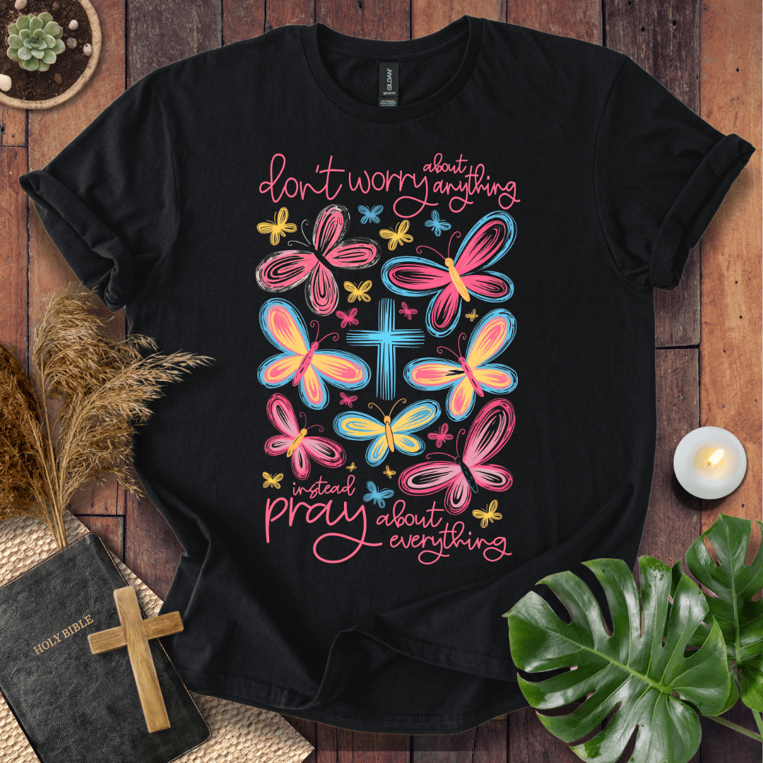butterfly faith shirt with a Bible and cross on a rustic wooden background.