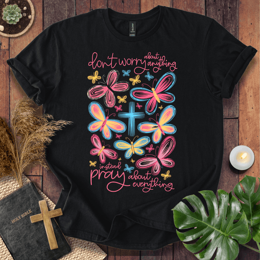 butterfly faith shirt with a Bible and cross on a rustic wooden background.