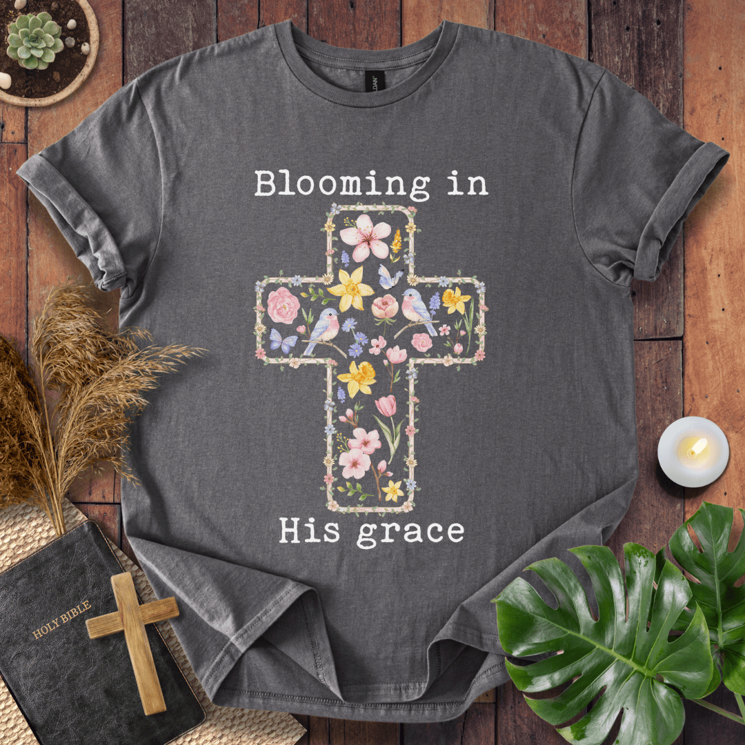 t-shirt featuring a cross filled with colorful wildflowers and birds, with the text "Blooming in His grace".