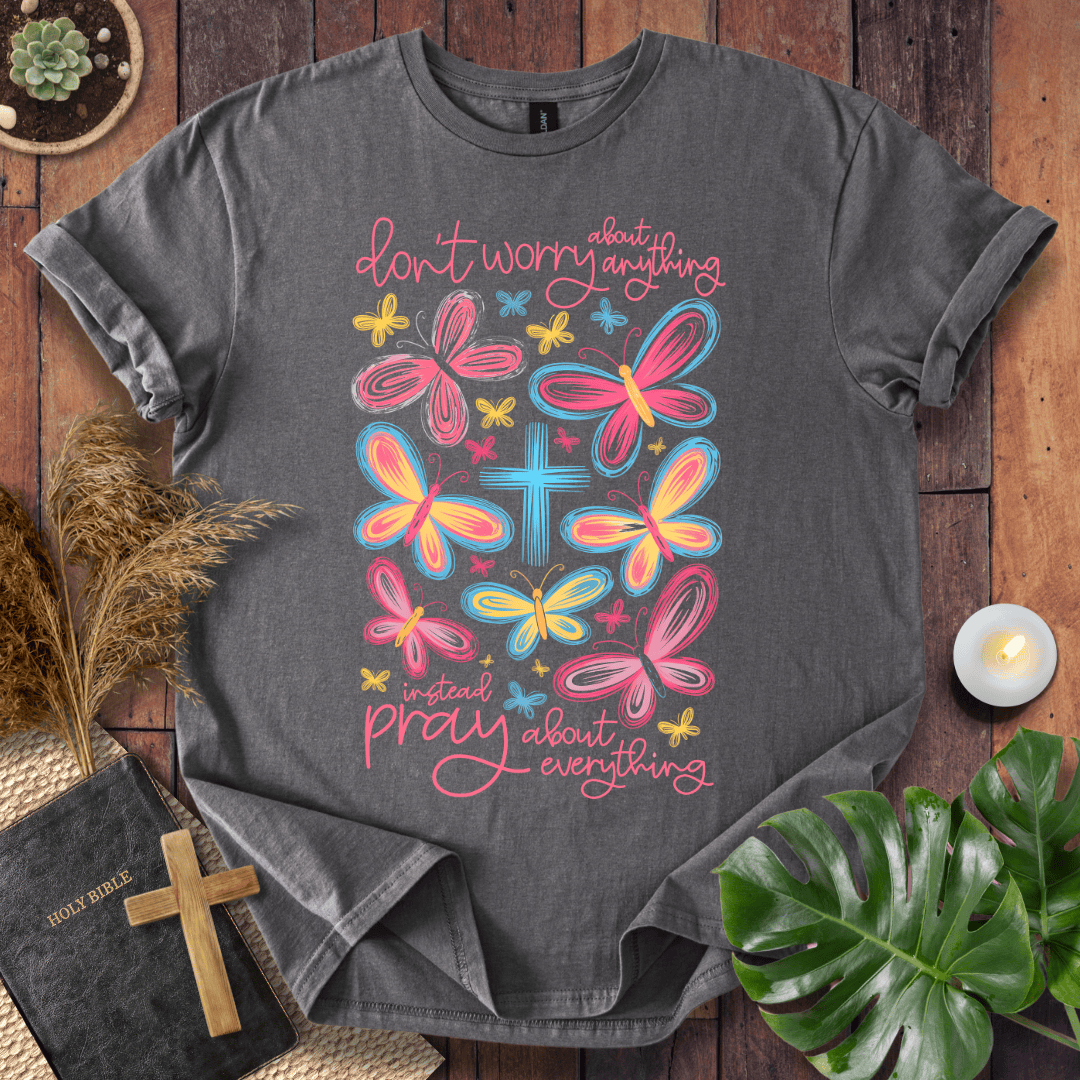 butterfly faith shirt with a Bible and cross on a rustic wooden background.