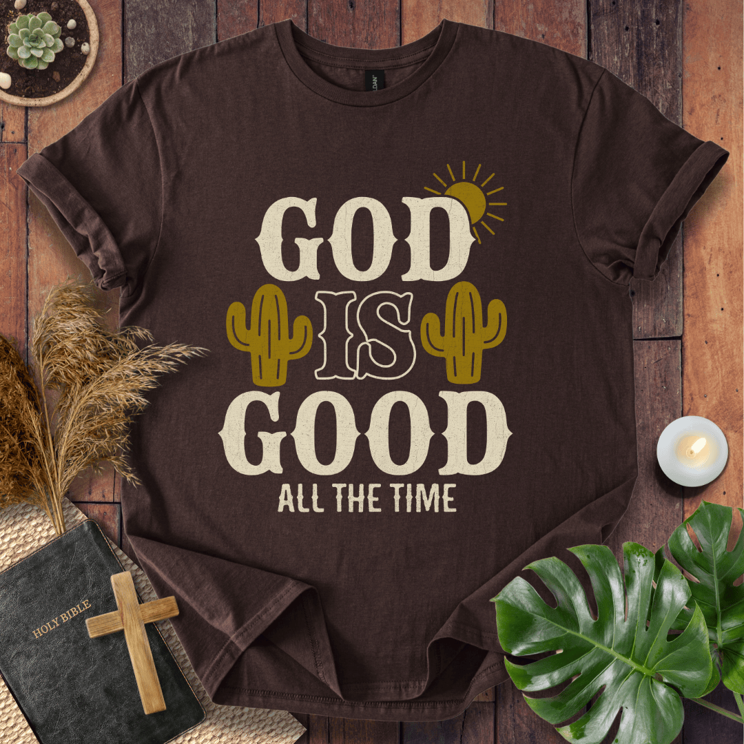 God Is Good All The Time t-shirt with cacti and sun graphics, styled with a Bible and wooden cross.