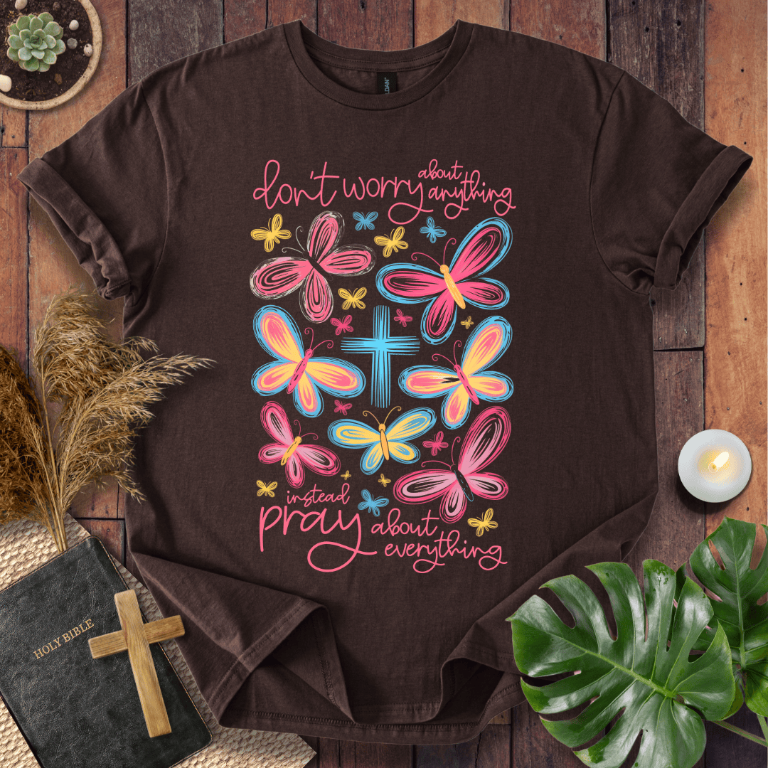 butterfly faith shirt with a Bible and cross on a rustic wooden background.