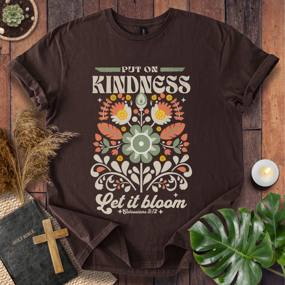 “Put On Kindness — Let It Bloom” Colossians 3:12 retro floral Christian t-shirt in folk-art style.