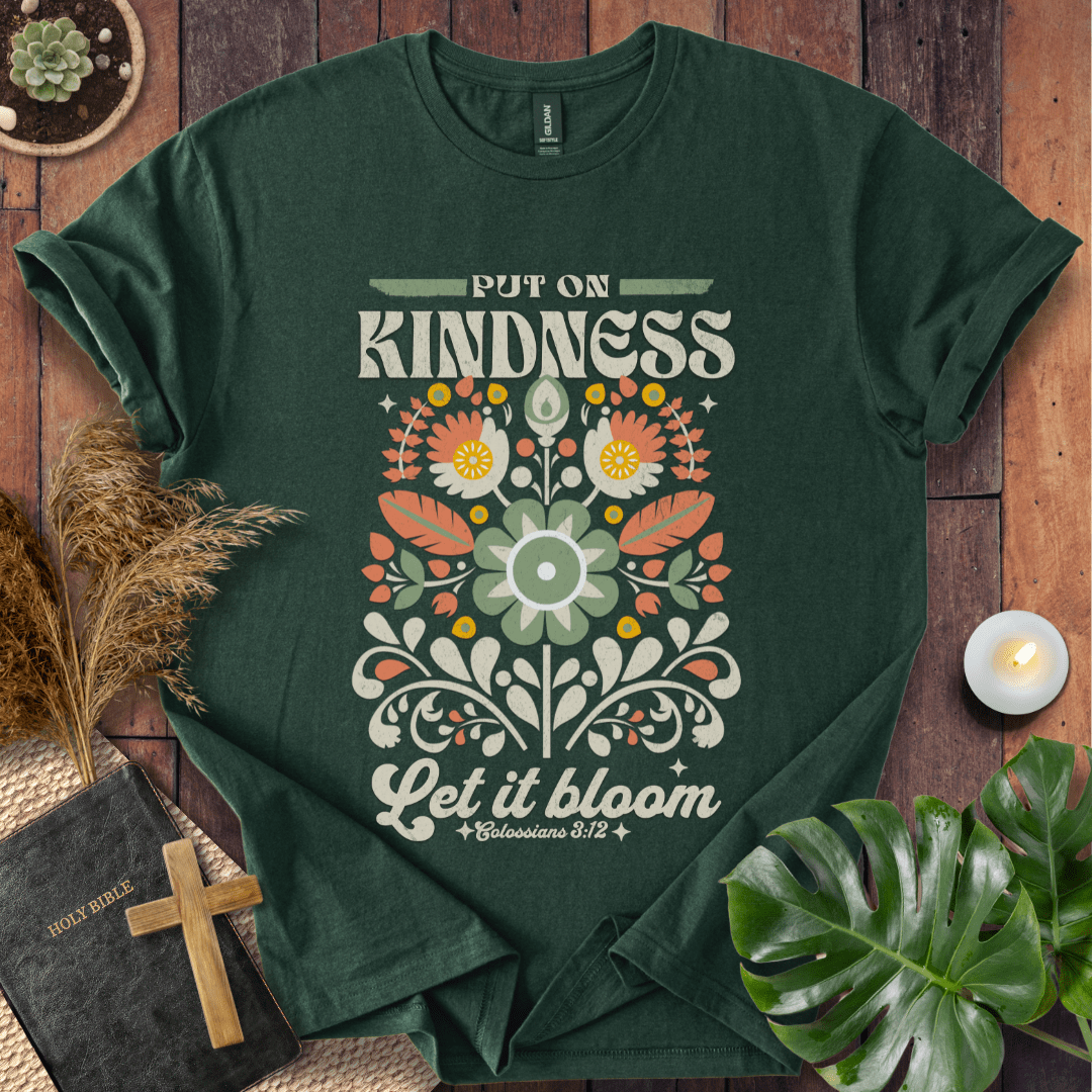 “Put On Kindness — Let It Bloom” Colossians 3:12 retro floral Christian t-shirt in folk-art style.