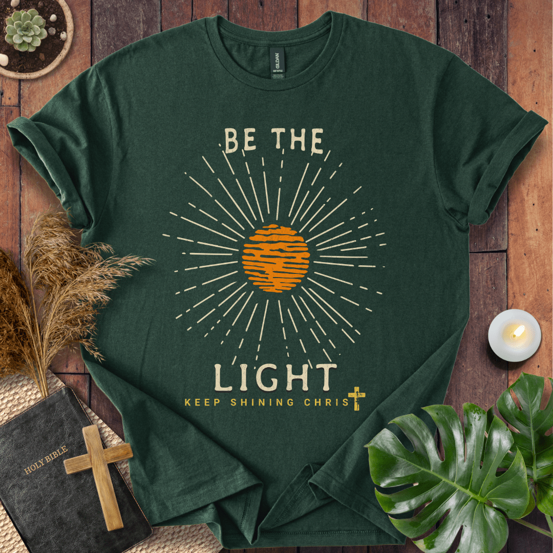 Be the Light Christian t-shirt—radiant sunburst with “Keep Shining Christ,” inspired by Matthew 5:14–16.