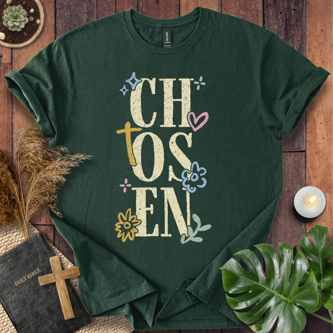 Distressed "CHOSEN" graphic on a t-shirt with a rustic gold cross and colorful boho wildflowers.