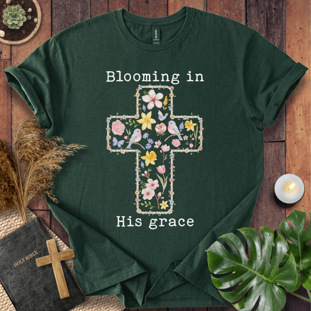 t-shirt featuring a cross filled with colorful wildflowers and birds, with the text "Blooming in His grace".