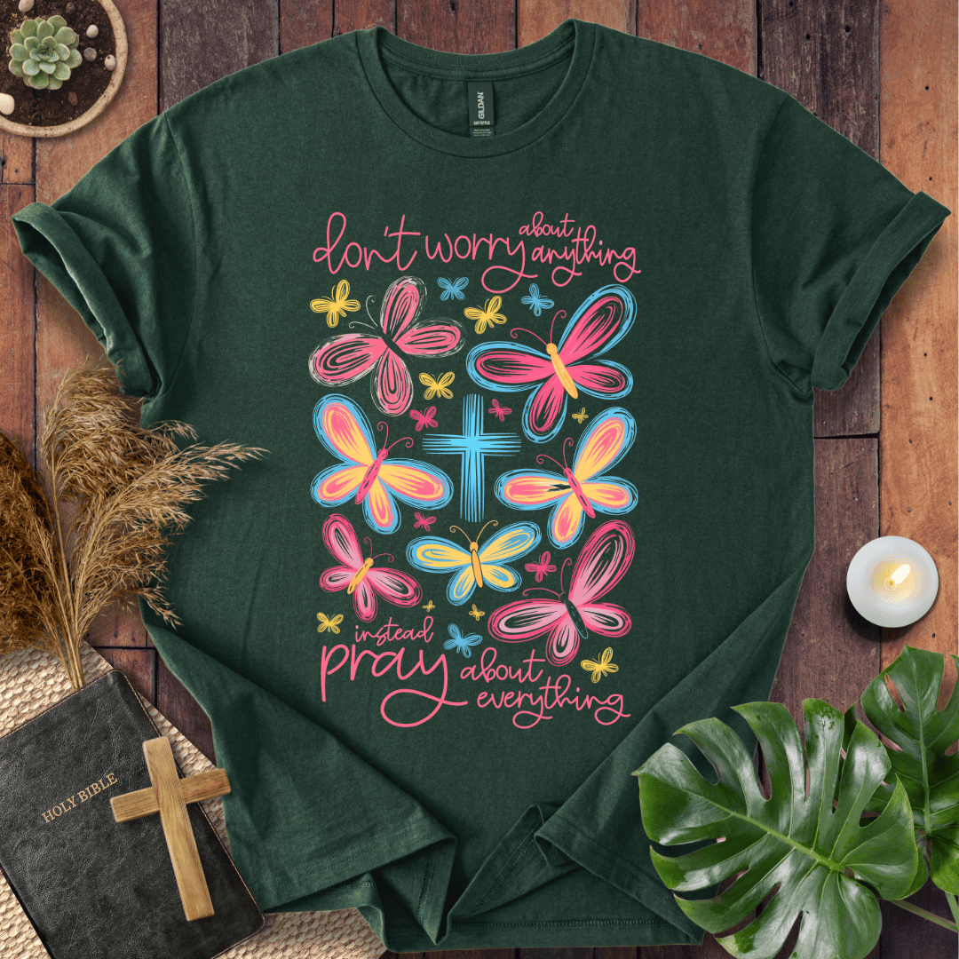 butterfly faith shirt with a Bible and cross on a rustic wooden background.