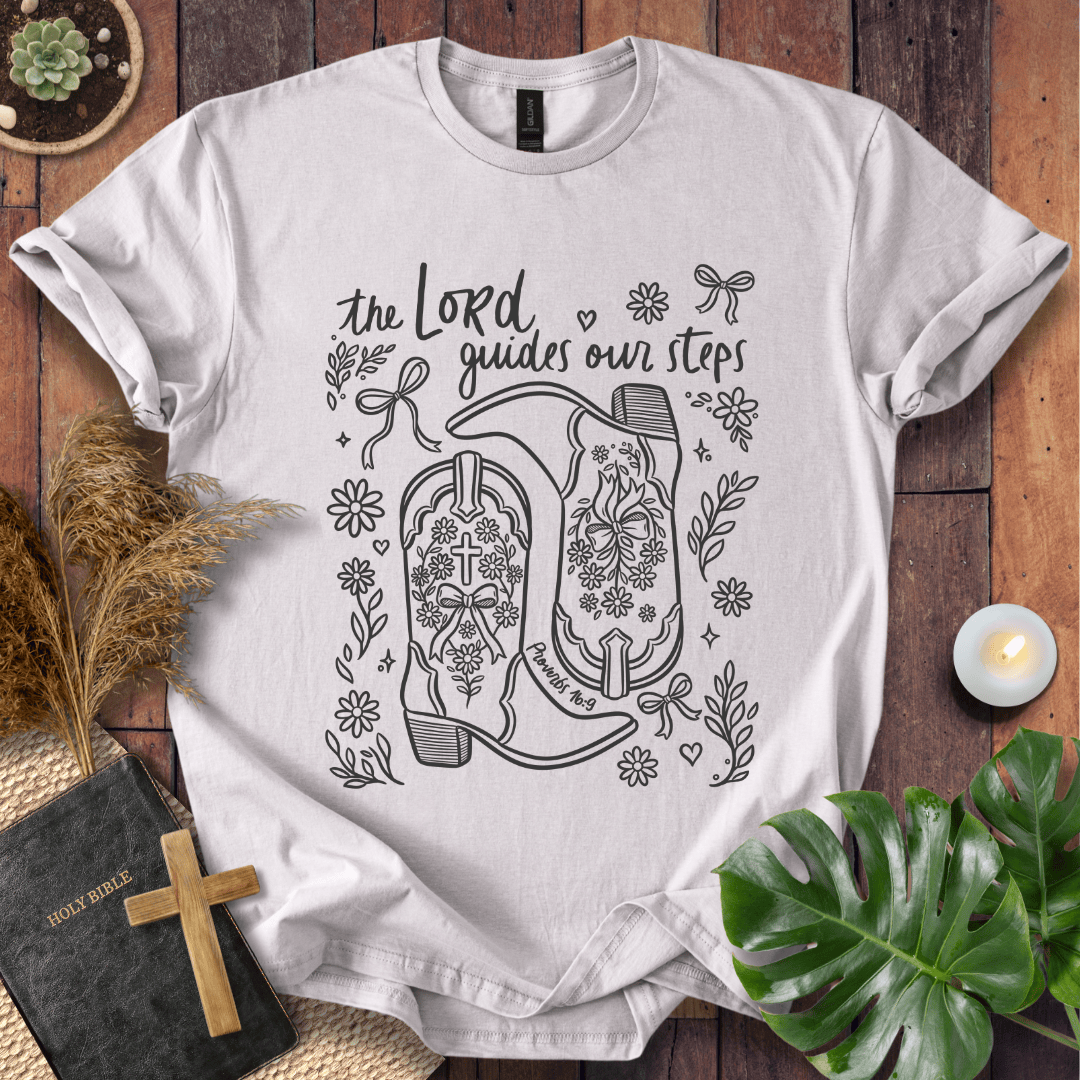 Line art cowboy boots with flowers and bows on a t shirt featuring Proverbs 16:9 "The Lord guides our steps."