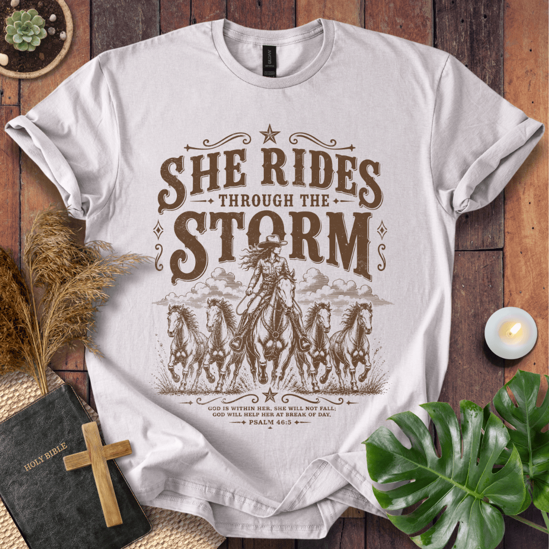 country t-shirt featuring a cowgirl riding a horse with the scripture text She Rides Through the Storm Psalm 46:5.