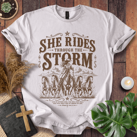 country t-shirt featuring a cowgirl riding a horse with the scripture text She Rides Through the Storm Psalm 46:5.
