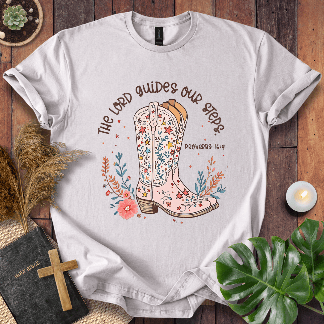 Christian t-shirt featuring a floral cowboy boot and the text The Lord Guides Our Steps Proverbs 16:9 in a rustic font.