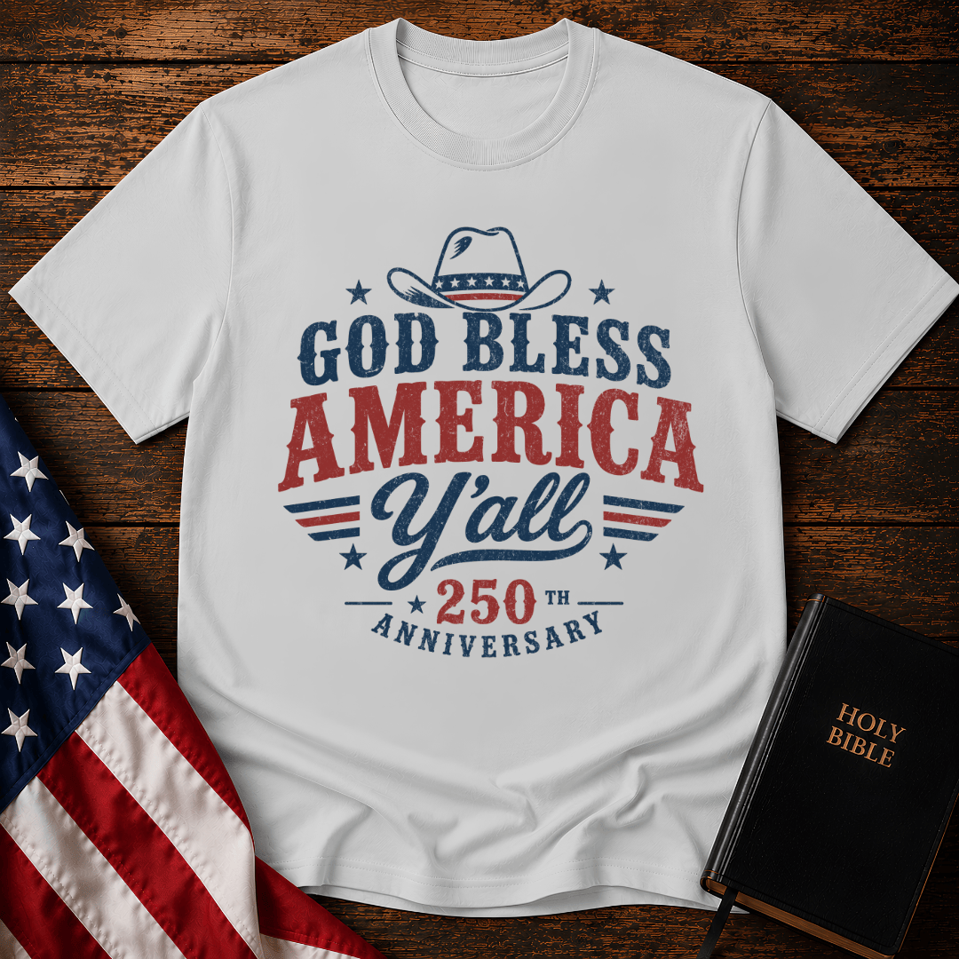 Christian t shirts featuring a Western cowboy hat, USA flag details, and God Bless America Y'all text on wood.