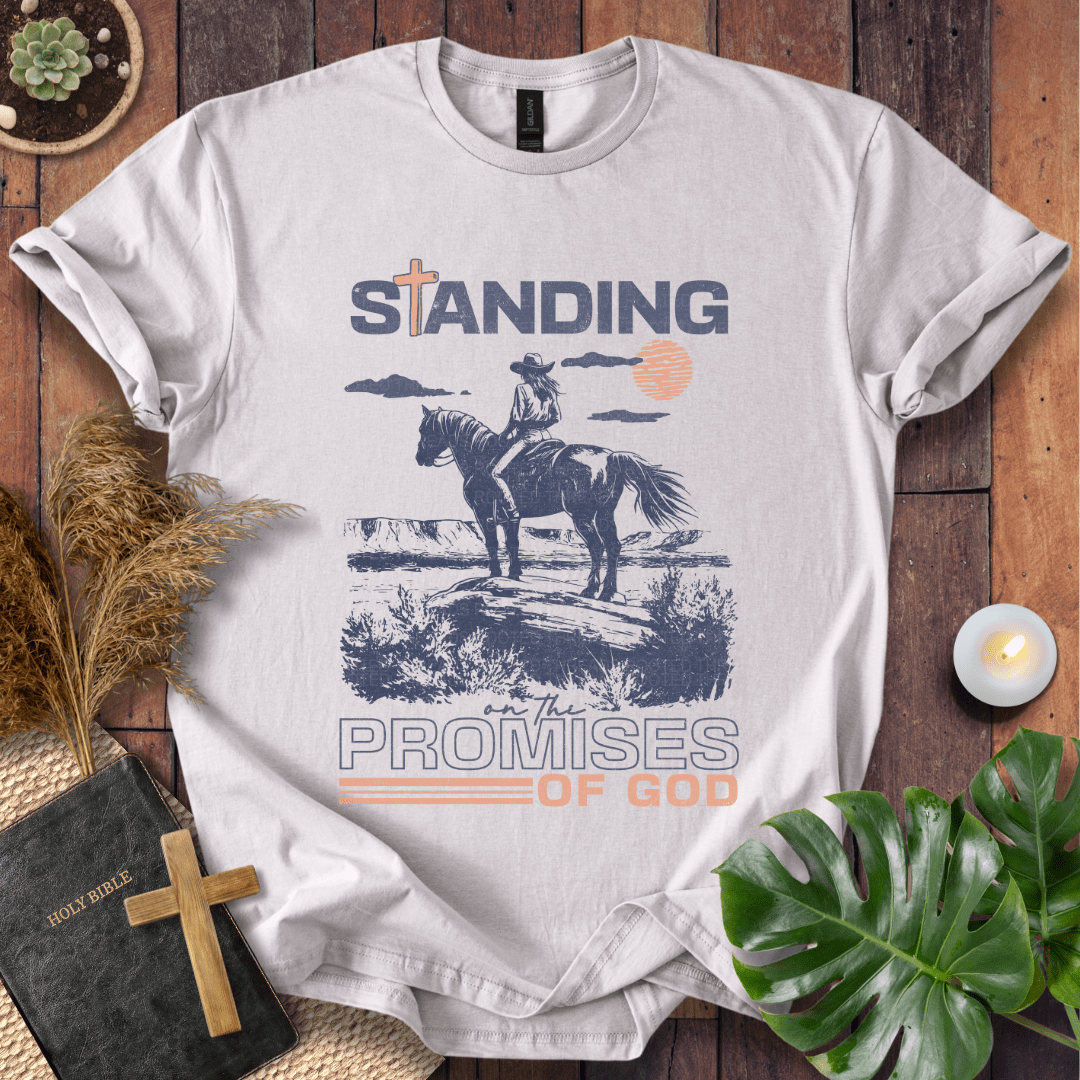 Standing on the Promises of God Christian t-shirt—cowgirl on horseback in western landscape with bold typographic message.
