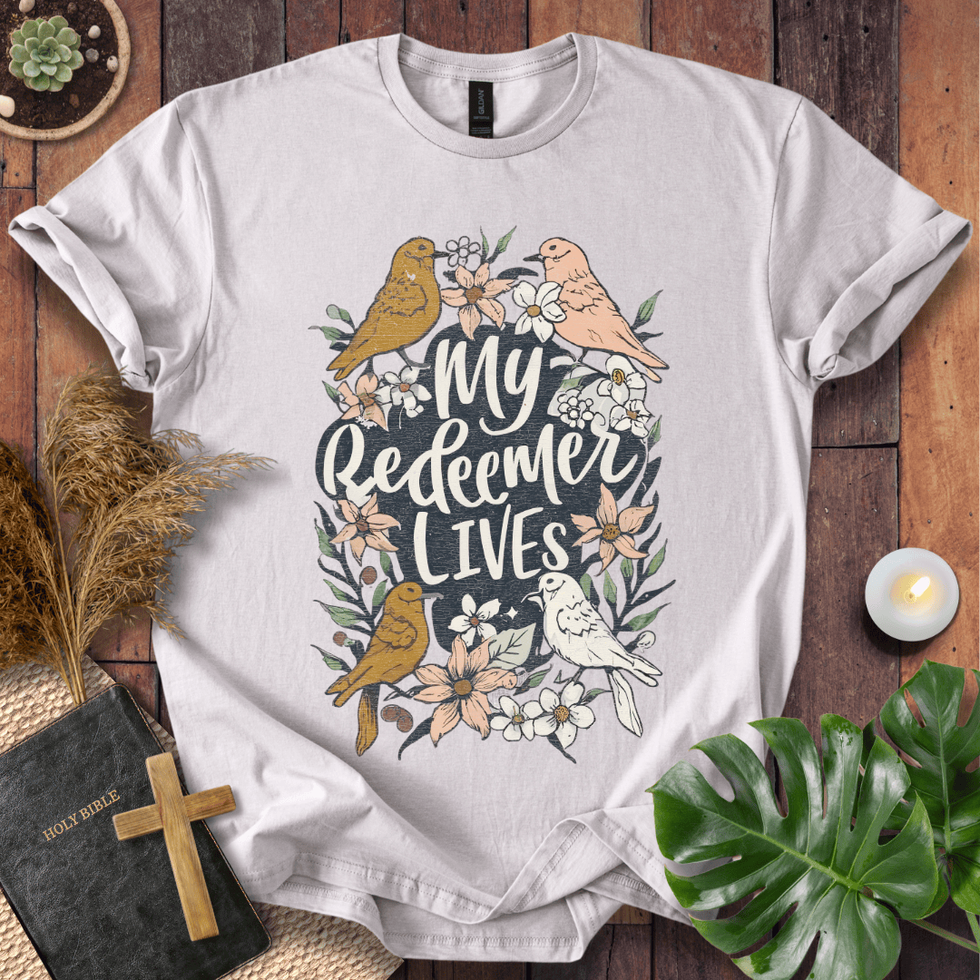 Christian Easter t-shirt with My Redeemer Lives text and birds on a wooden table next to a Holy Bible and a wooden cross.