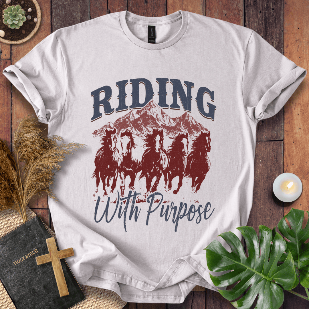 t-shirt with navy and rust graphic of five running horses, mountains, and "Riding With Purpose" vintage text.