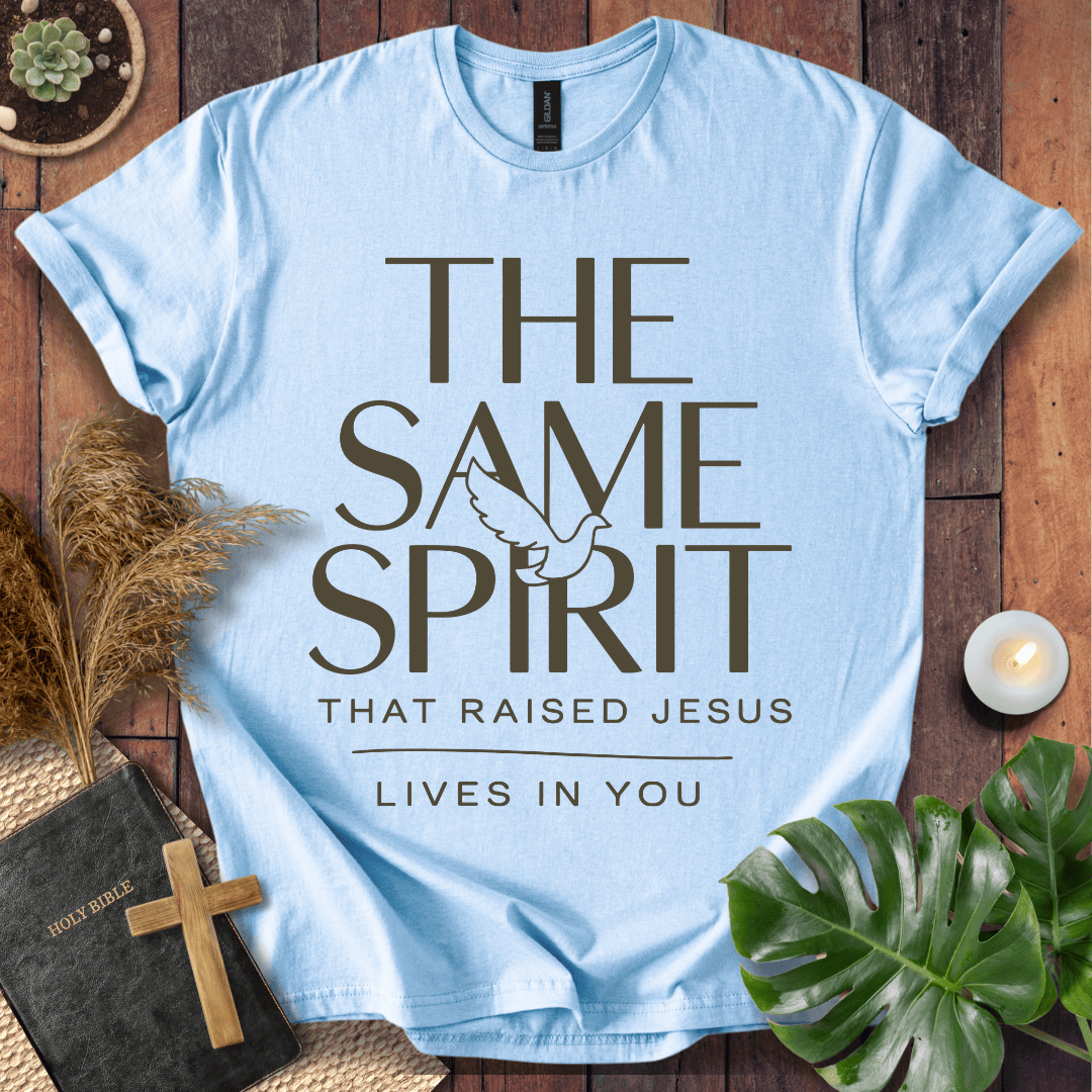 Easter Christian t-shirt with "The Same Spirit That Raised Jesus Lives In You" text and dove icon on wooden background.