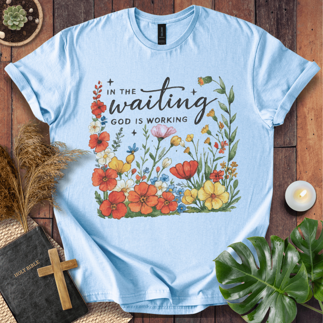 “In the Waiting God Is Working” Christian t-shirt with hand-lettered script and floral frame; encouragement faith tee.