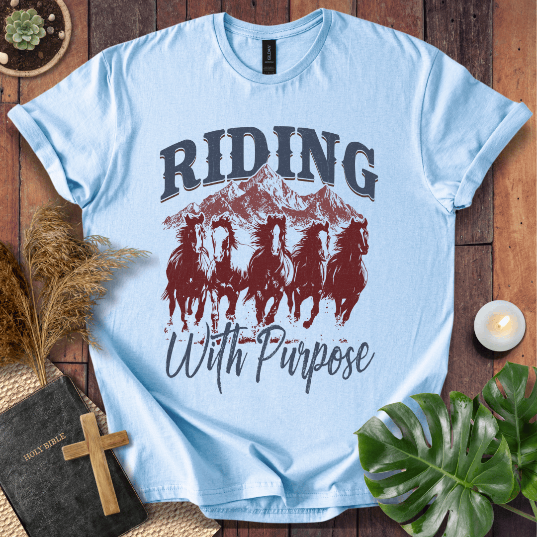 t-shirt with navy and rust graphic of five running horses, mountains, and "Riding With Purpose" vintage text.