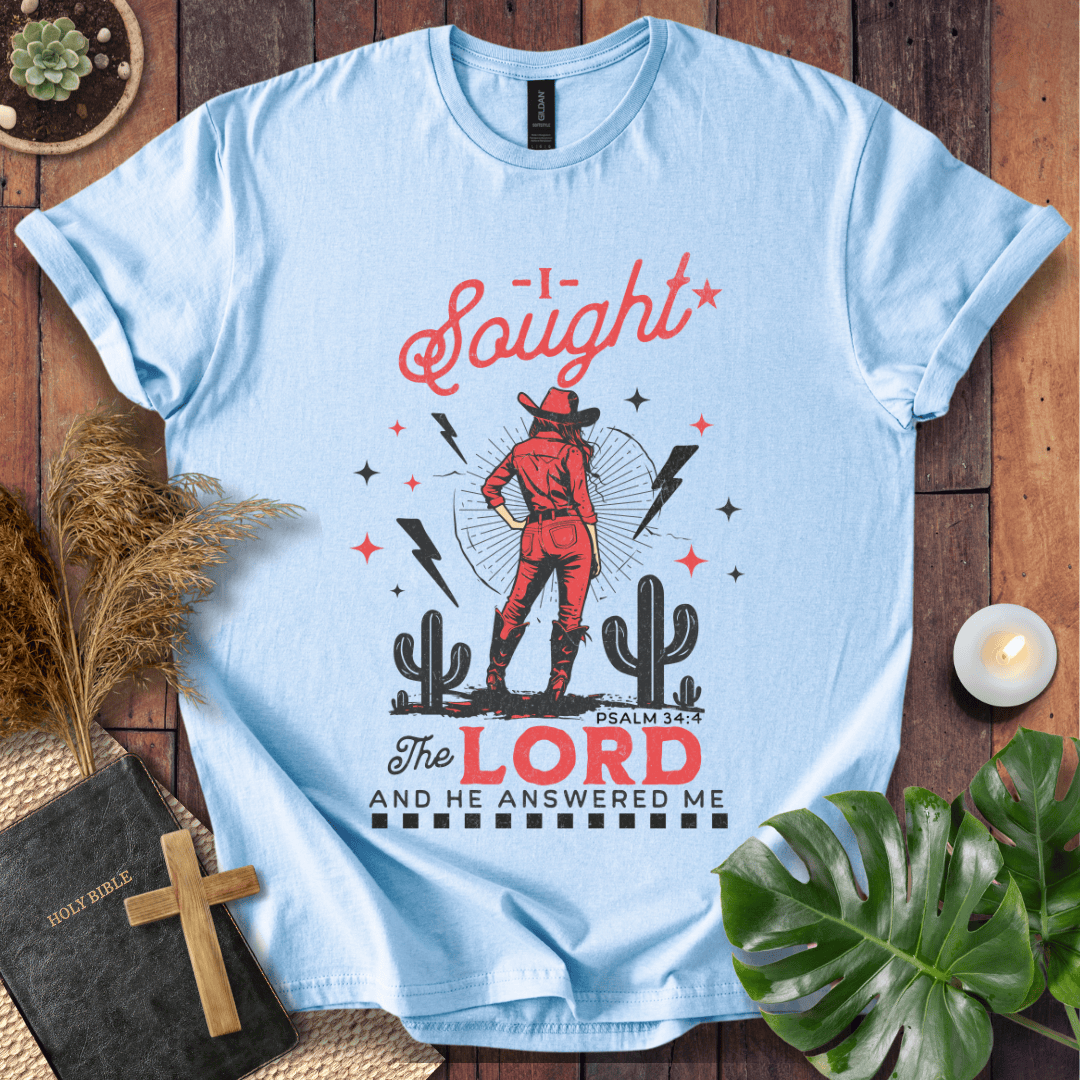 Cowgirl in red standing in a desert with cacti and lightning, text reads I Sought The Lord And He Answered Me Psalm 34:4.