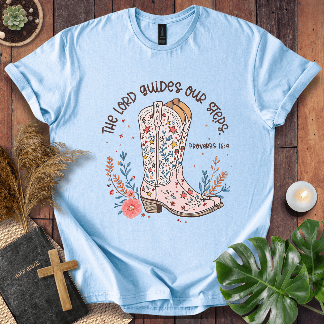 Christian t-shirt featuring a floral cowboy boot and the text The Lord Guides Our Steps Proverbs 16:9 in a rustic font.