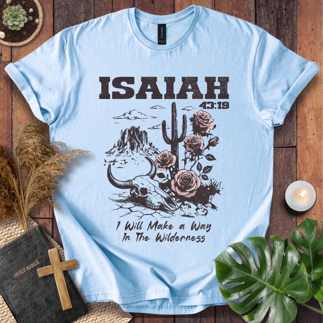 Light blue t-shirt with 'Isaiah 43:19' design on a wooden surface with plants and a Bible.