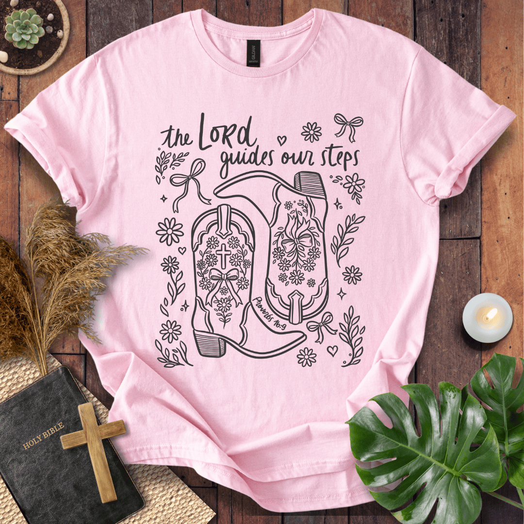 Line art cowboy boots with flowers and bows on a t shirt featuring Proverbs 16:9 "The Lord guides our steps."