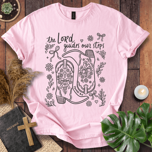 Line art cowboy boots with flowers and bows on a t shirt featuring Proverbs 16:9 "The Lord guides our steps."