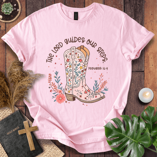 Christian t-shirt featuring a floral cowboy boot and the text The Lord Guides Our Steps Proverbs 16:9 in a rustic font.