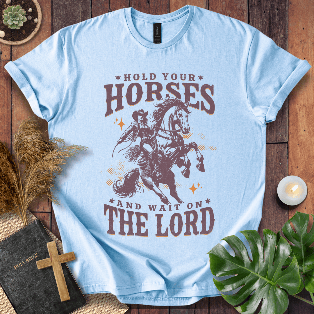 Cowgirl riding a rearing horse on a t-shirt with text saying Hold Your Horses and Wait on the Lord.