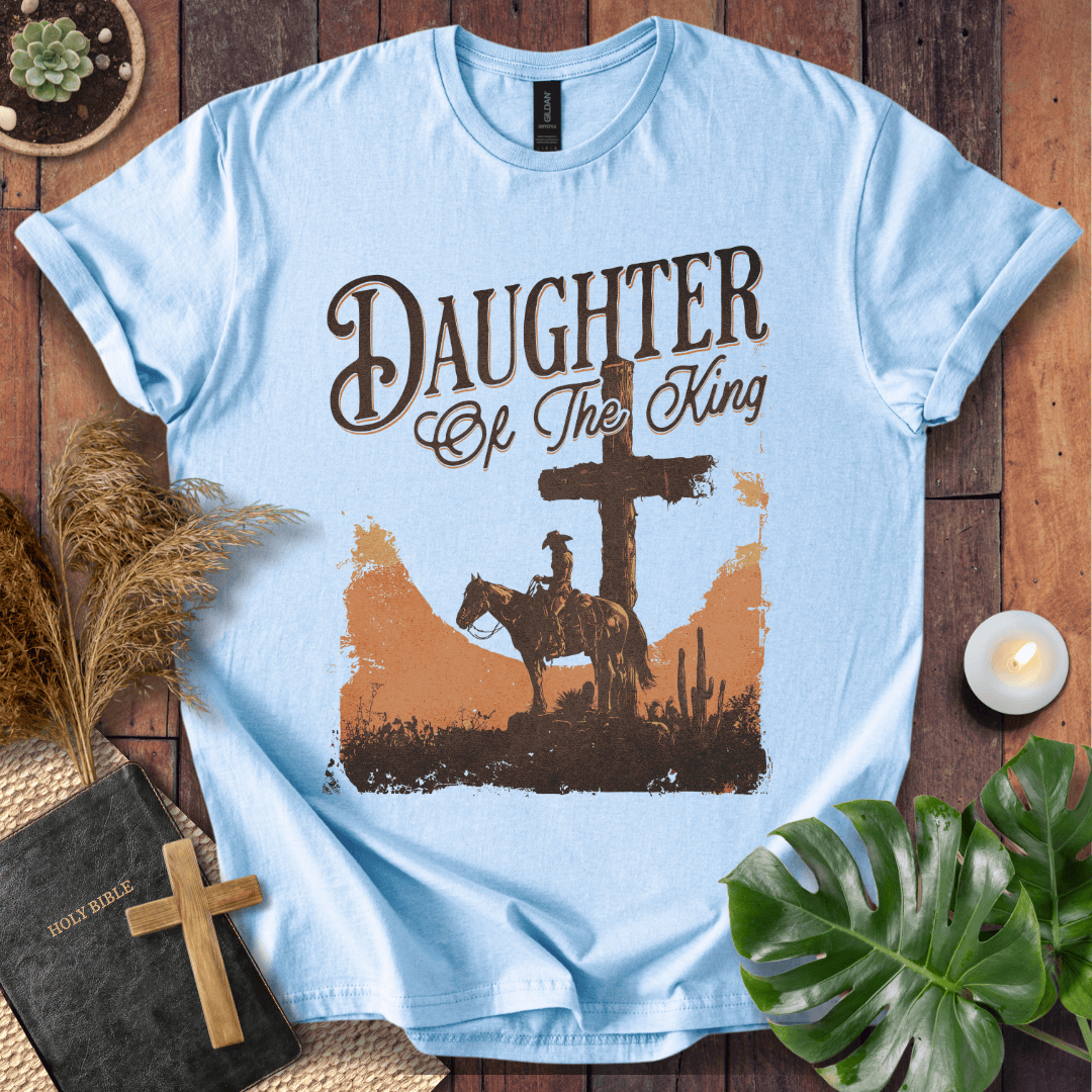 Western Christian t shirt for women featuring a rider on a horse by a cross in a desert sunset.