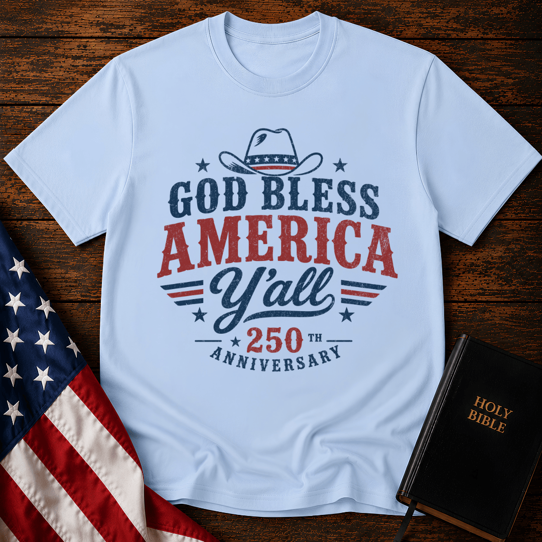 Christian t shirts featuring a Western cowboy hat, USA flag details, and God Bless America Y'all text on wood.