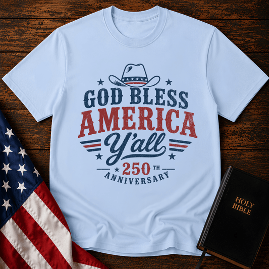 Christian t shirts featuring a Western cowboy hat, USA flag details, and God Bless America Y'all text on wood.