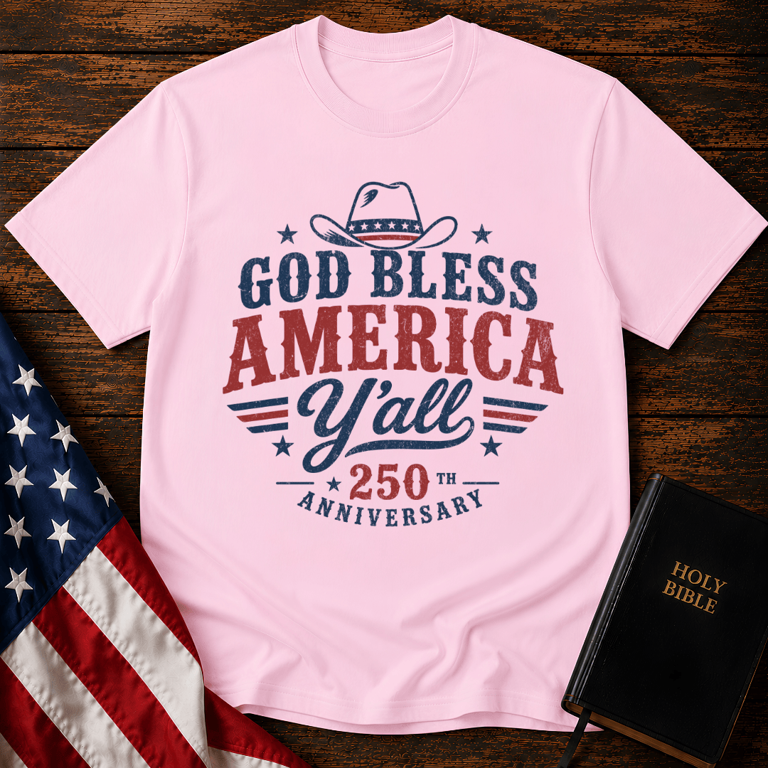 Christian t shirts featuring a Western cowboy hat, USA flag details, and God Bless America Y'all text on wood.