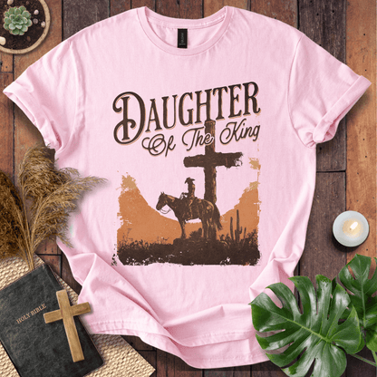 Western Christian t shirt for women featuring a rider on a horse by a cross in a desert sunset.