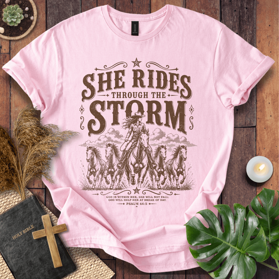 country t-shirt featuring a cowgirl riding a horse with the scripture text She Rides Through the Storm Psalm 46:5.