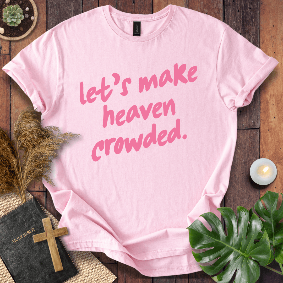 A light pink short-sleeve T-shirt with the phrase 'let's make heaven crowded.' printed in pink script across the front.